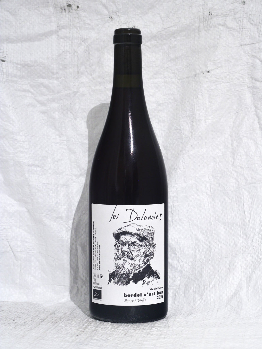 Vorderansicht der Flasche Domaine les Dolomies - Bordel c'est Bon 2023. Ein eleganter, saftiger Rotwein aus der Rebsorte Trousseau, gewachsen auf Kalk- und Mergelböden im Jura, Frankreich.