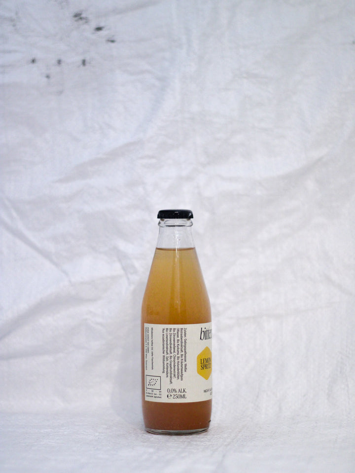 Detailaufnahme des Bitterschön Etiketts von Pona Bitter Lemon, zeigt die natürliche Trübung durch hohen Fruchtanteil und den Verzicht auf künstliche Zusätze.